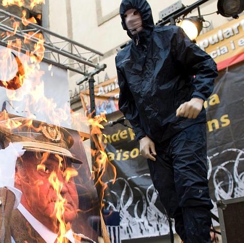 Unos encapuchados queman una foto del Rey y una bandera de España en la Diada