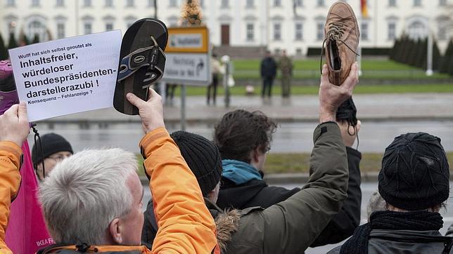 Cientos de manifestantes protestan contra el presidente alemán zapato en alto