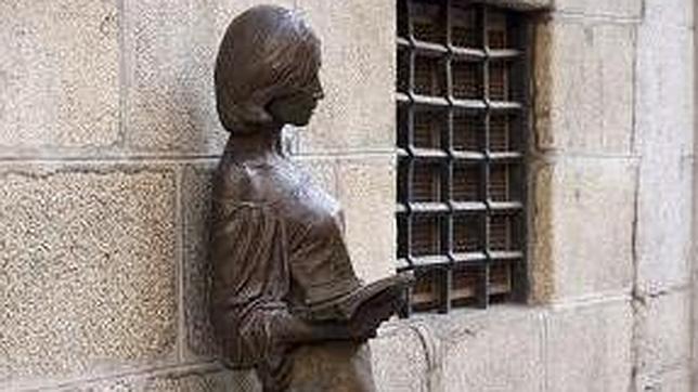 La escultura, que se apoya en la pared, simula a una joven leyendo