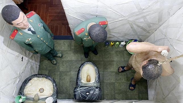 Ai Weiwei, duchándose vigilado por los dos policías