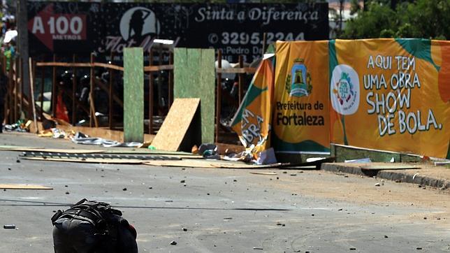 Un policía, junto a las piedras lanzadas este miércoles por manifestantes junto al estadio Castelao en Fortaleza