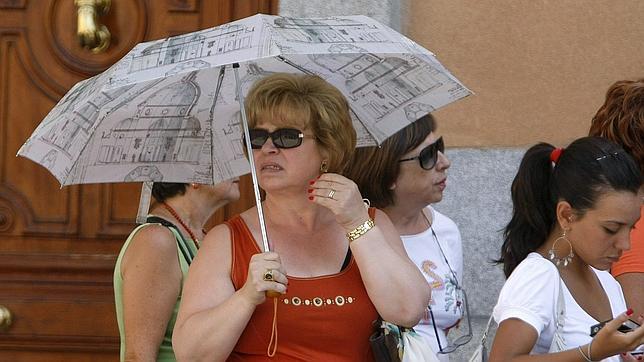 Una señora se protege de los rayos del sol con un paraguas