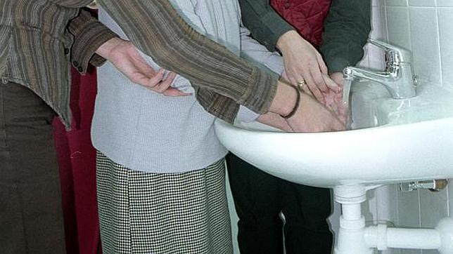 Una familia se lava las manos en el lavabo