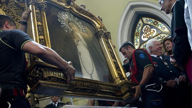 Los bomberos, descendiendo en cuadro de la Virgen de La Paloma, el 15 de agosto