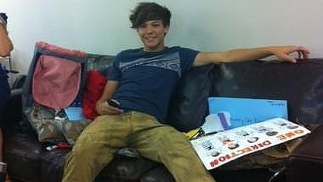 Louis descansa en un sofá mientras está de gira y rodeado de regalos de fans