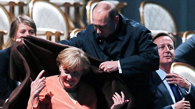 Putin, un galán que cubre los hombros de Merkel