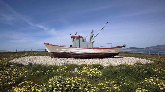 Un viejo barco de pesca decora un jardín de una factoría de Pescanova en Baiona