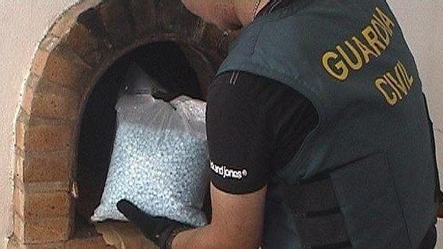 Un guardia civil extrae una bolsa con pastillas de ketamina de un zulo