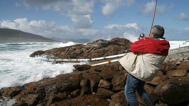 Un hombre intenta pescar en aguas de la localidad coruñesa de Caión