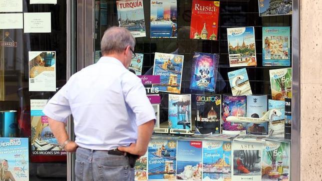 Un hombre mira las ofertas de una agencia de viajes