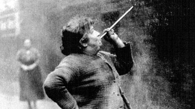 Despertadora («knocker-up», en inglés) con una cerbatana; fotografía tomada en Londres, en 1931