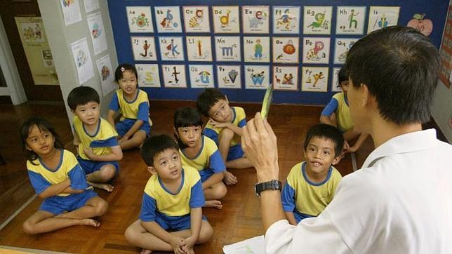 Un profesor junto a sus alumnos en un centro educativo en Singapur