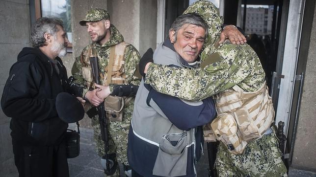 Un manifestante prorruso abraza este lunes a un hombre armado frente a un edificio de la administración regional de Lugansk (Ucrania)