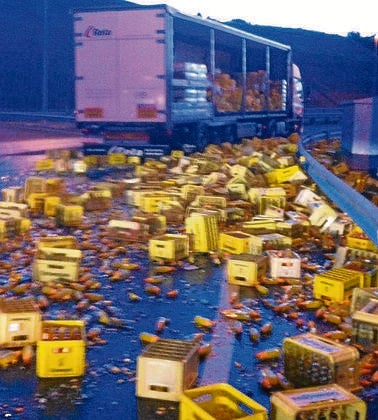 Espectacular vuelco de un camión cargado de botellas en la carretera de Ávila