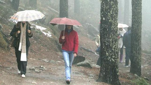 Unos caminantes sorprendidos por la lluvia en la sierra de Guadarrama