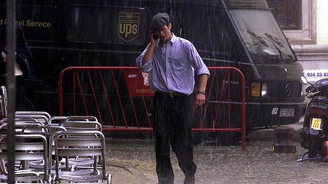 Un hombre hace una llamada telefónica durante una tormenta de verano