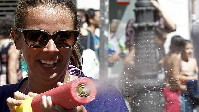 Una mujer dispara una pistola de agua en la Batalla Naval de Vallecas