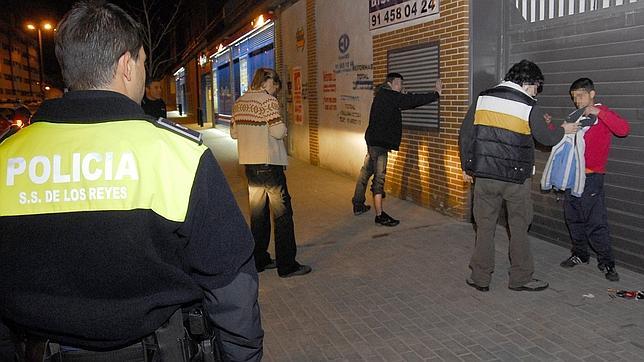 Unos agentes cachean a unos jóvenes en una ronda rutinaria en Madrid