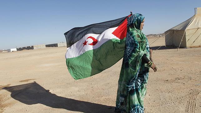 Una saharaui sostiene la bandera de la República Árabe Saharaui Democrática (RASD)