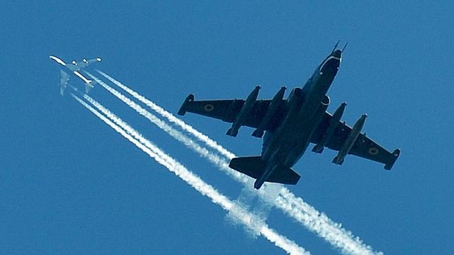 Un avión de Malaysia Airlines pasa por encima de un caza en una imagen de archivo