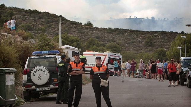 Vecinos de la urbanización Monte Zamora tras ser desalojados de forma preventiva ante la proximidad del incendio forestal declarado esta tarde en el término de Vall d,Uixó