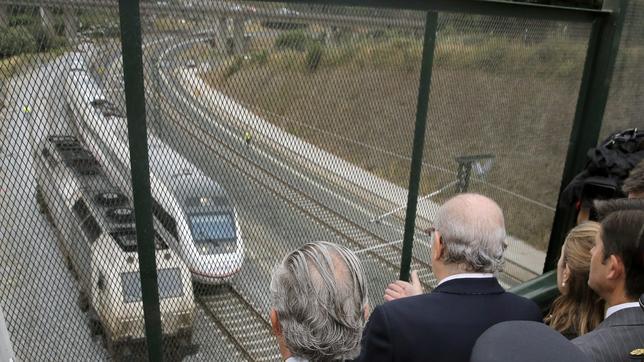 Un grupo de autoridades observa la curva de A Grandeira al paso de un tren