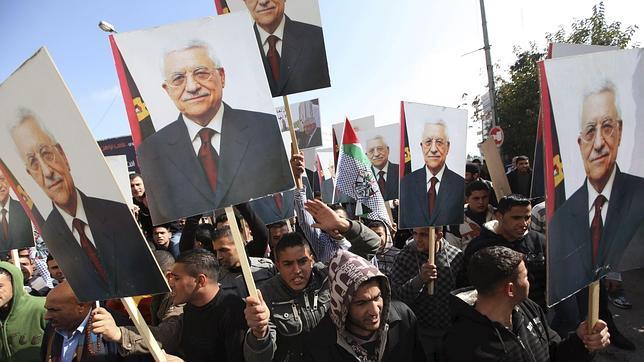 Simpatizantes de Al Fatah muestran carteles con la efigie de Mahmud Abás en Ramala