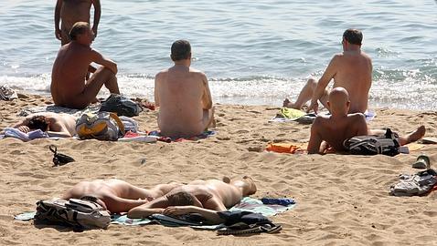 Varios bañistas disfrutan, desnudos, de la playa y el sol