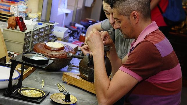 Un artesano realiza una pieza de damasquinado