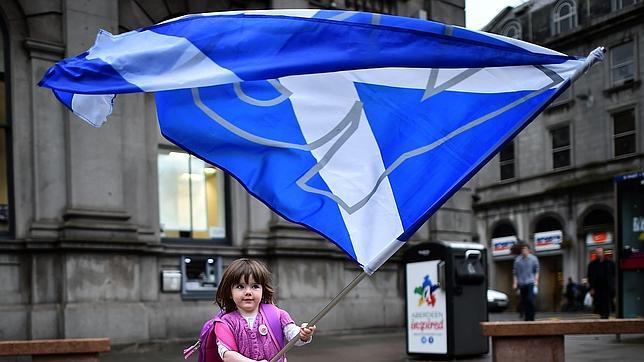 Una niña juega con una bandera escocesa en Edimburgo