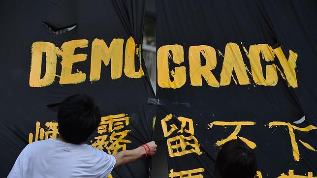Manifestantes por la democracia ponen una bandera en una plaza de Hong Kong