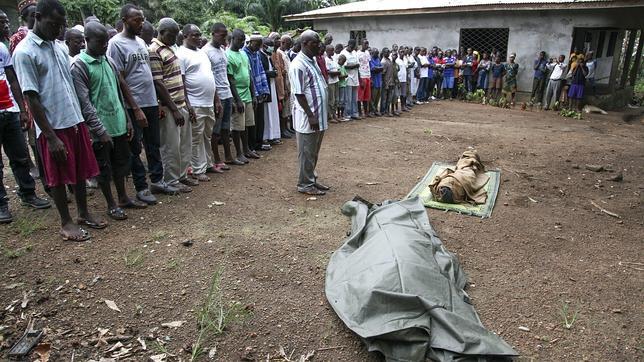 Un grupo de musulmanes liberianos reza antes de enterrar a dos víctimas del ébola en la comunidad de Banjor, a las afueras de Monrovia, Liberia