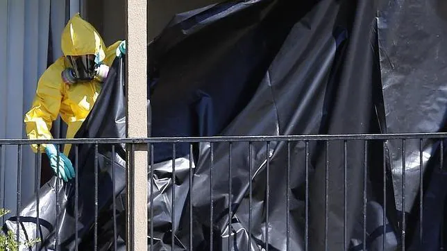 Un trabajador vestido con un traje para manipular material peligroso cubre la fachada del apartamento donde permanece aislado Thomas Eric Duncan, un ciudadano liberiano diagnosticado con ébola en Dallas, EE.UU.