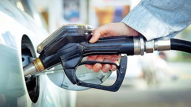 Un conductor reposta combustible en una estación de servicio