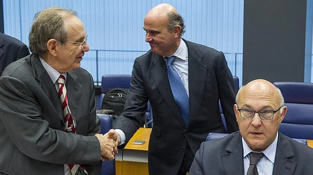 El ministro español de Economía y Competitividad, Luis de Guindos (c), en presencia de su homólogo galo e italiano