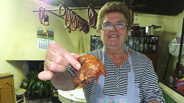 María Jiménez muestra un trozo de lechón ibérico frito según su técnica