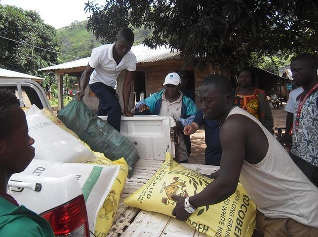 Distribución de los alimentos aportados por la comunidad parroquial a unas casas con familias aisladas por el ébola