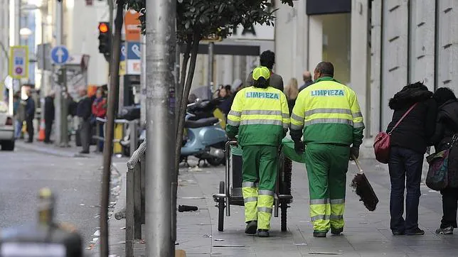 Dos operarios de limpieza trabajando en una calle de Madrid