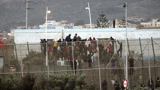 Los inmigrantes encaramados hoy en la valla de Melilla