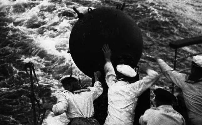 Marinos alemanes proceden a arrojar una mina al mar desde la popa de un buque minador