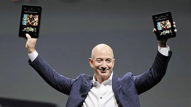 Jeff Bezos sostiene dos tabletas Kindle Fire