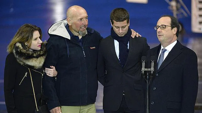 Serge Lazarevic (c) junto a sus hijos y el presidente francés a su llegada a París