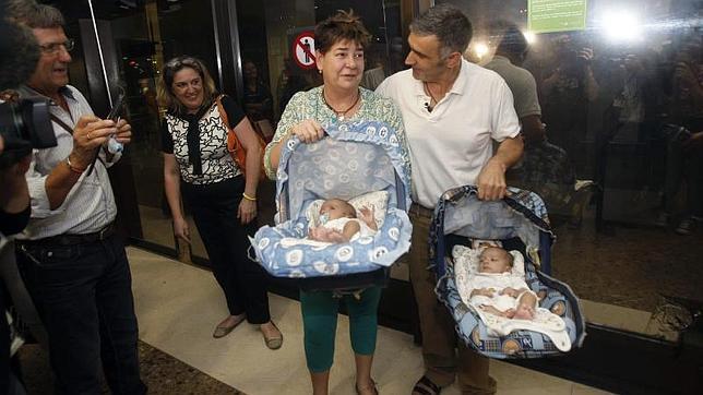 La madre asturiana Ana María Coto (c), y los dos bebés, Carmen y Lucas, nacidos de un vientre de alquiler en la India, junto al padre José Luis Vidal (d)