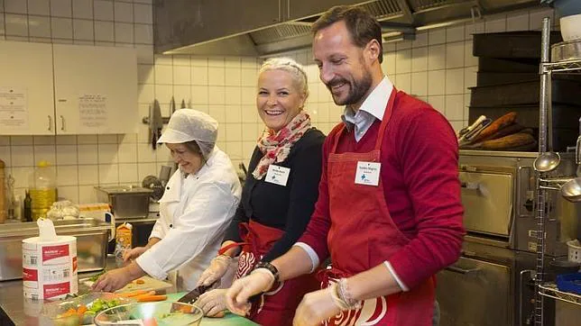 Haakon de Noruega y Mette-Marit cocinando en un comedor social noruego