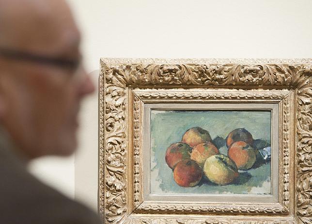 Un hombre junto a una naturaleza muerta de Cézanne en la muestra del Museo Thyssen