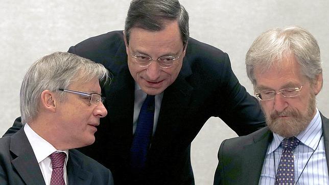 Praet (derecha) junto a Mario Draghi (centro)