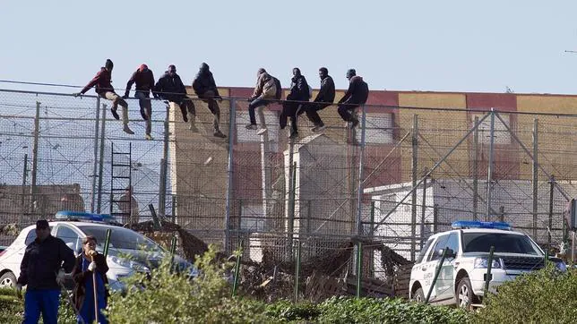 Subsaharianos encaramados a la valla de Melilla tras el asalto masivo de este martes