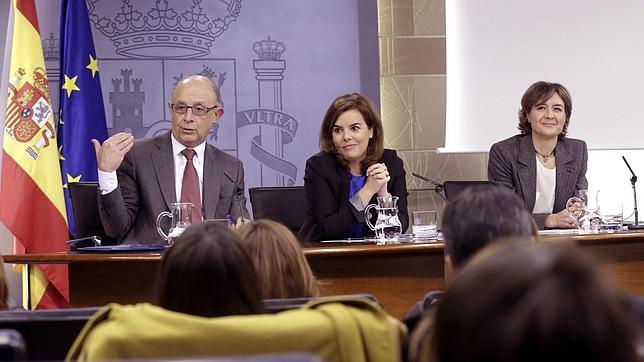 A la izquierda, el ministro de Hacienda, Cristóbal Montoro, en la rueda de prensa posterior al Consejo de Ministros