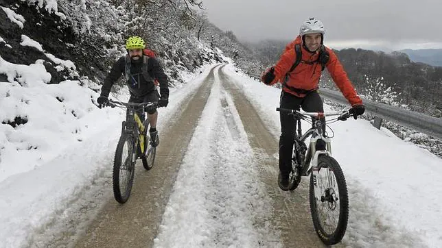 Dos ciclistas suben entre la nieve al Santuario de San Miguel de Aralar (Navarra)