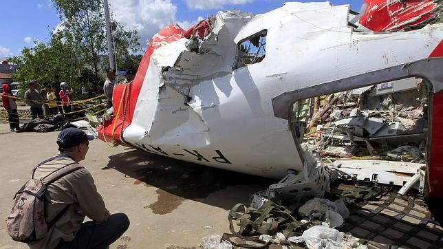 Un investigador inspecciona los restos del avión de AirAsia QZ8501 en Panglima Utar Kumai en Borneo (Indonesia)